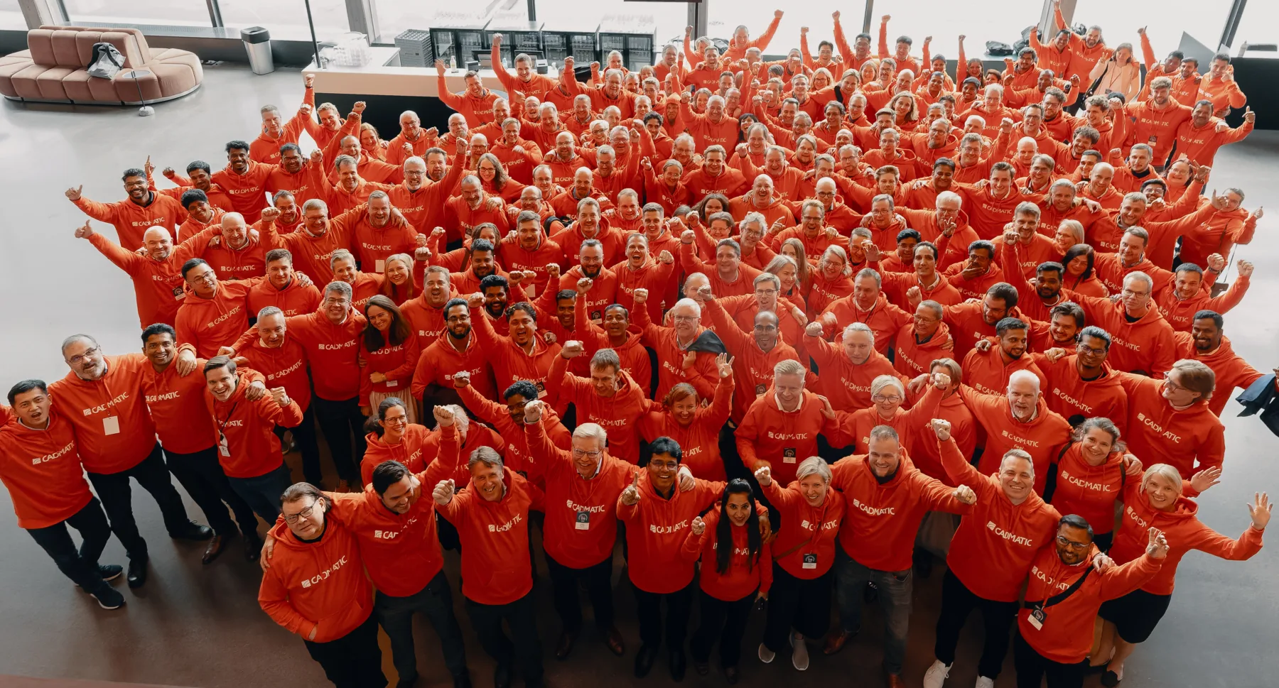 Large group of Cadmatic employees dressed in orange