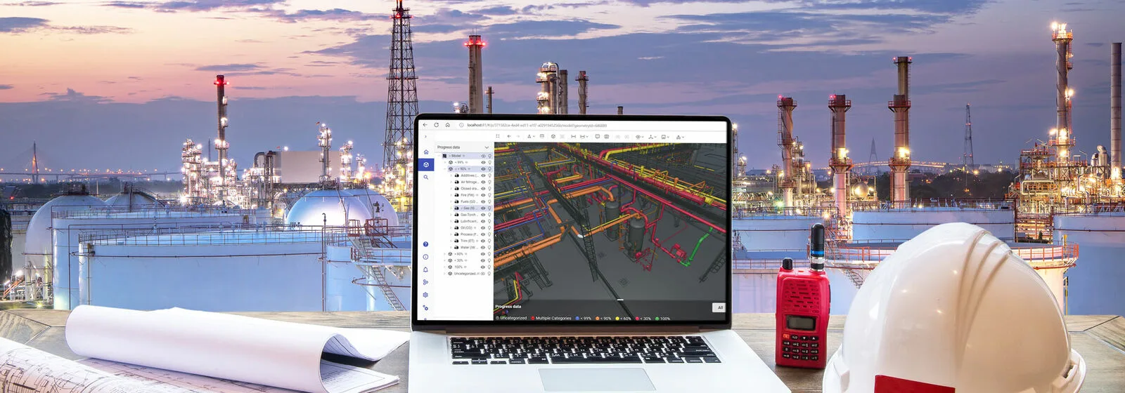 Industrial plant in the background and a computer with Cadmatic software and an engineer helmet next to it.