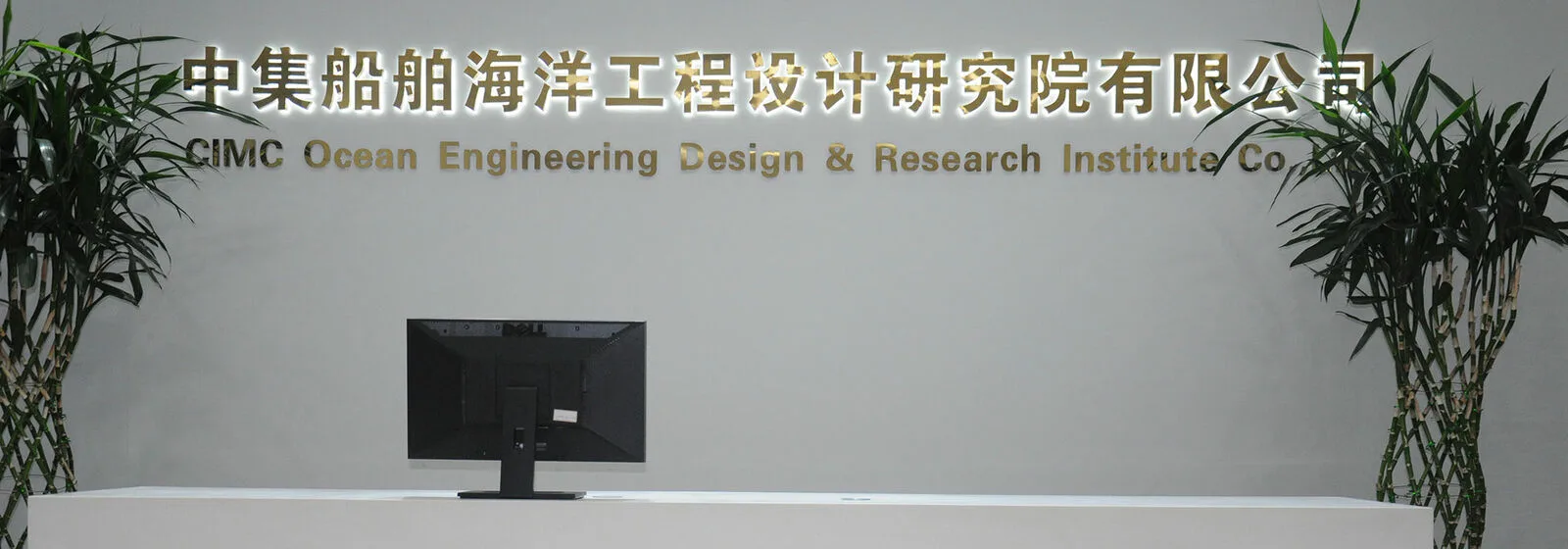 Reception area of CIMC Ocean Engineering Design & Research Institute with a white desk, plants, and bilingual signage on the wall