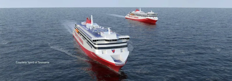 Two red and white passenger ferries labeled 'Spirit of Tasmania' sailing on the ocean, with one ferry in the foreground and another in the background