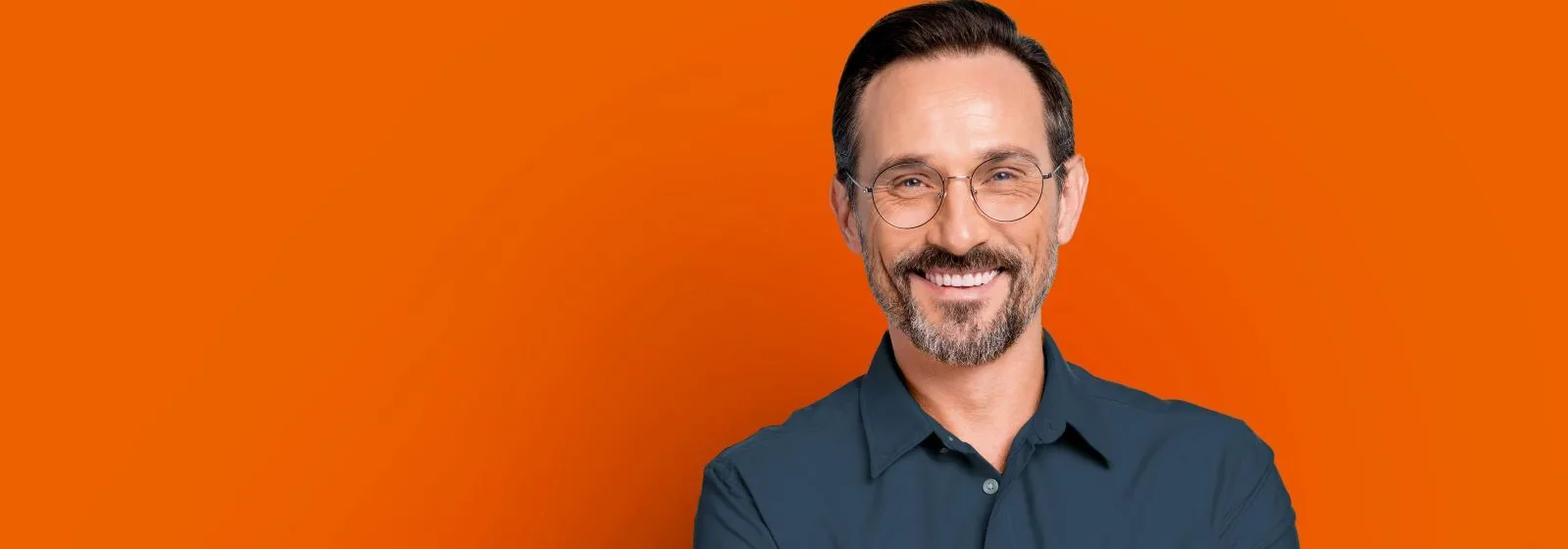Person with arms crossed against an orange background, representing confidence in smart engineering solutions.