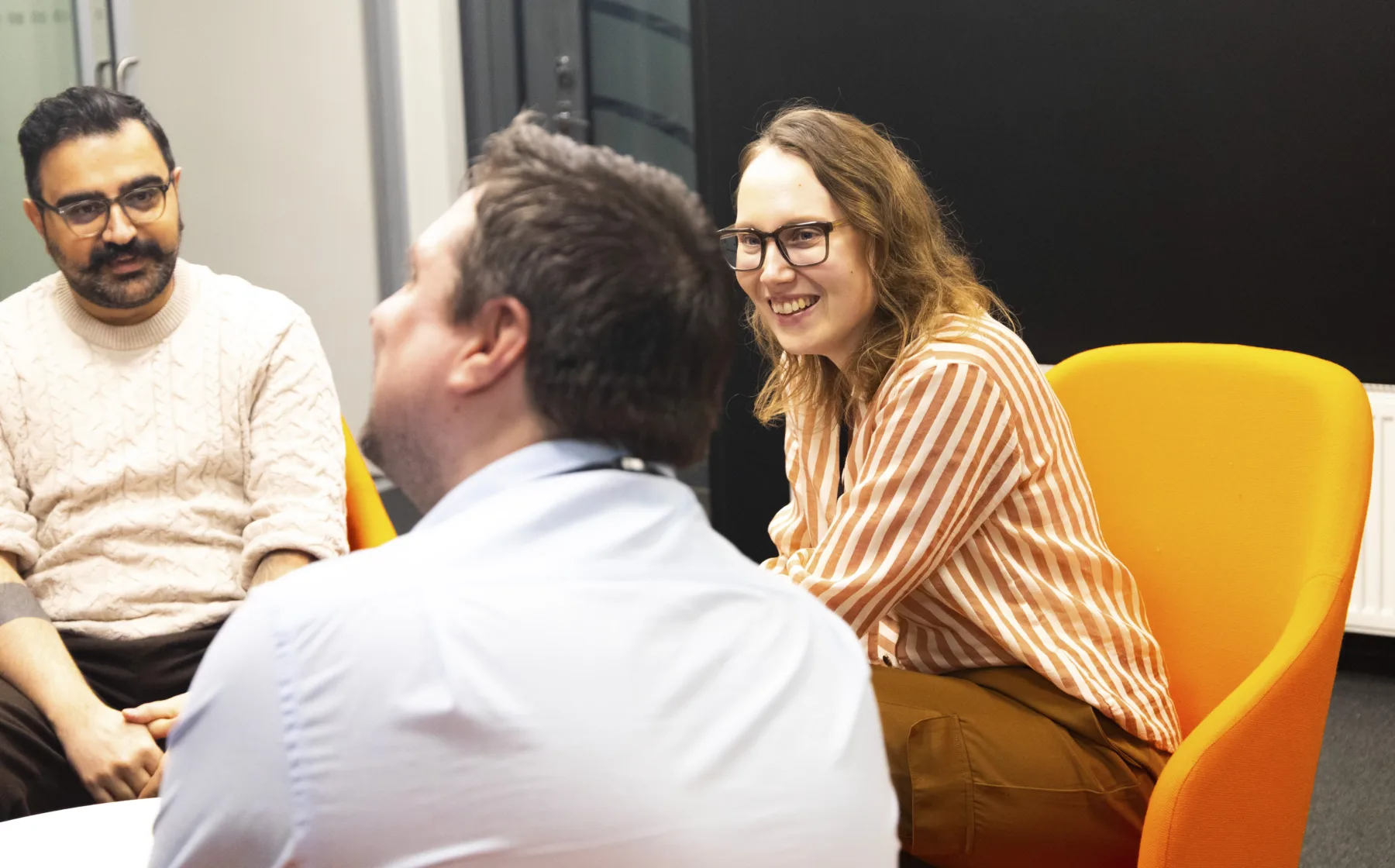 Cadmatic employees sitting in an informal meeting room