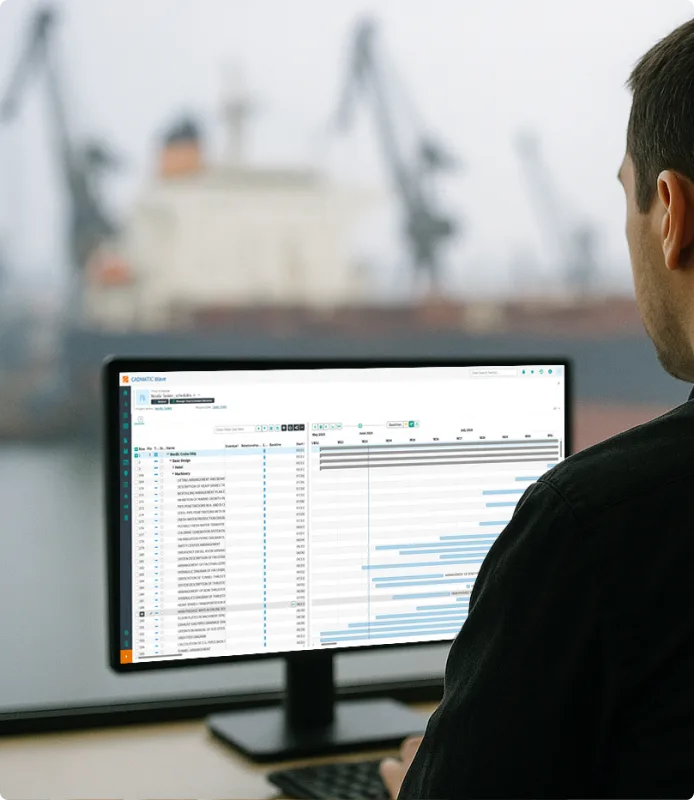 Man looking at a computer screen showing the CADMATIC Wave PLM solution for shipbuilding, which provides process efficiency and change control.