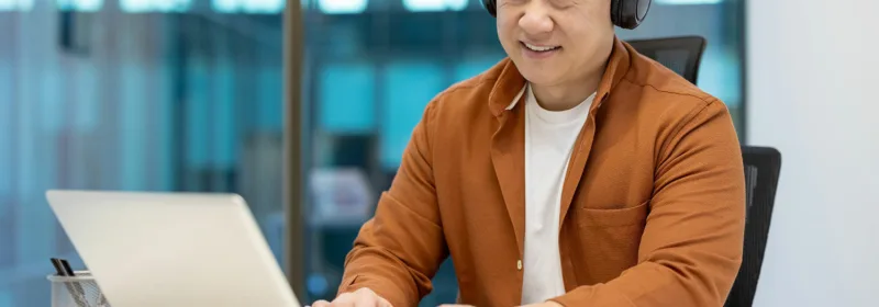 Engineer with headphones working in an office on a computer